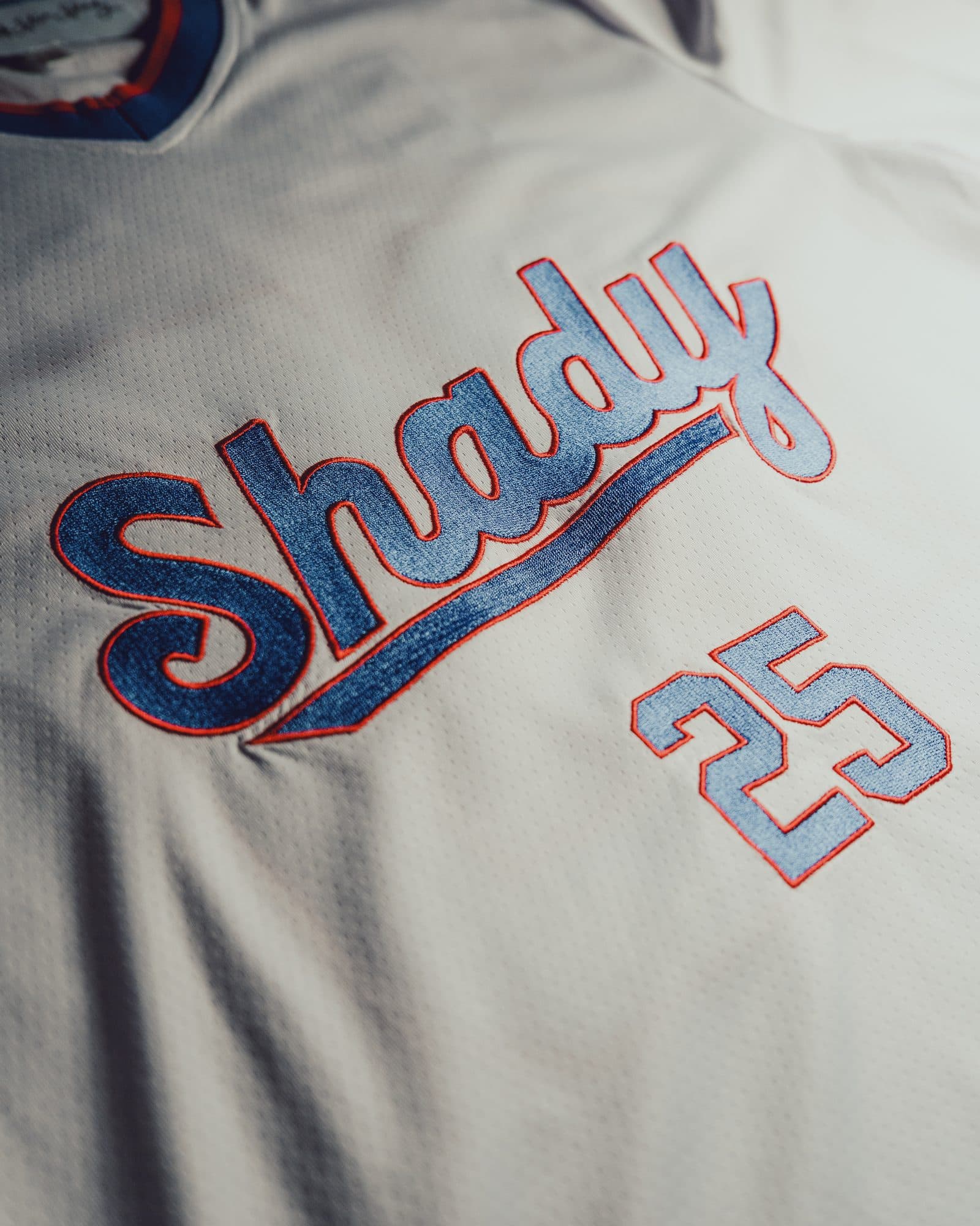 Front of a pale grey mesh football jersey with Shady in blue script outlined in red and a blue 25 below it, the blue and red collar at the top edge.