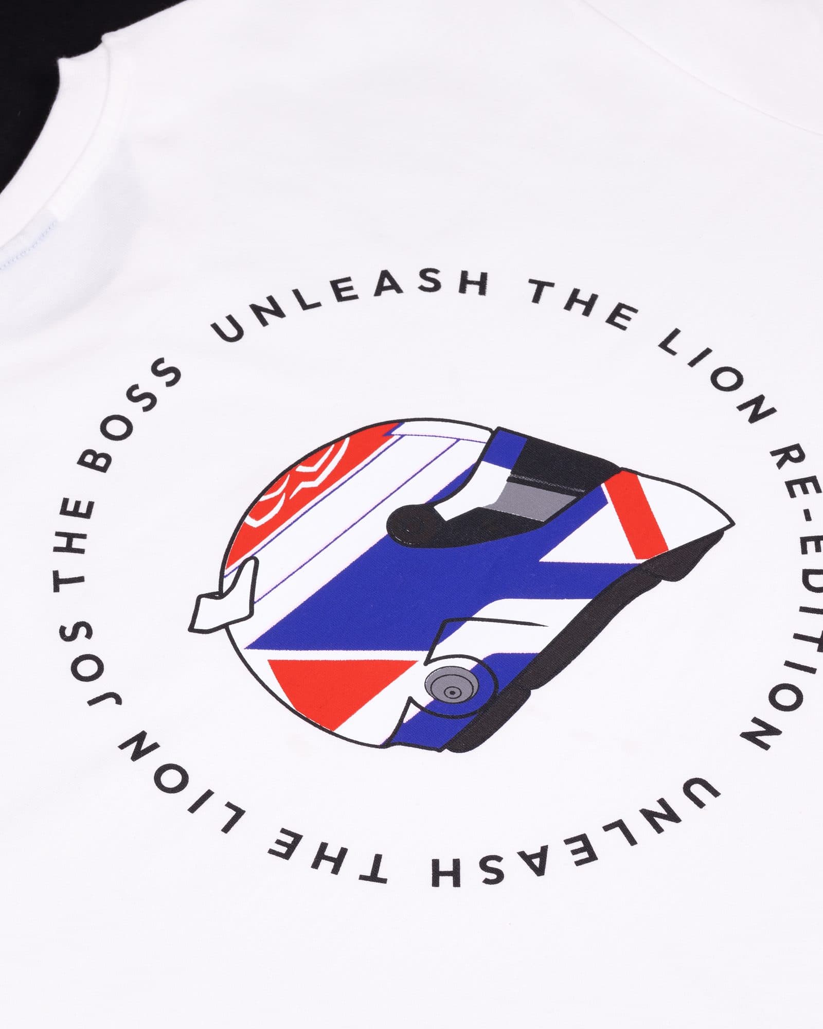 Back of a white T-shirt below the collar, printed with a red, white and blue racing helmet inside a ring of black capitals reading JOS THE BOSS, UNLEASH THE LION RE-EDITION and UNLEASH THE LION.
