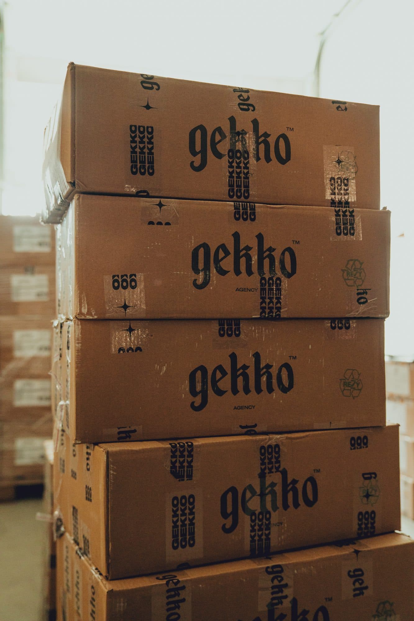 Stacked shipping boxes printed with the gekko logo in the GEKKO Agency warehouse in Rotterdam
